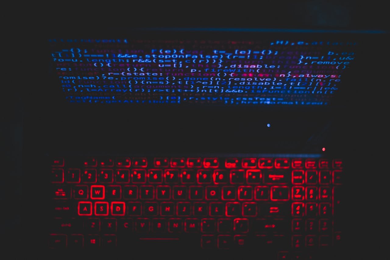 Services Dark-themed laptop setup with a red glowing keyboard and code on screen, ideal for tech enthusiasts.